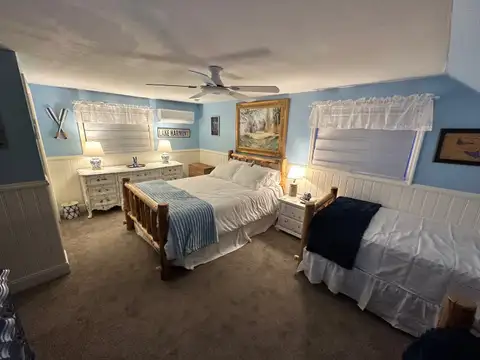 Bedroom 5 with rustic log queen bed, twin bed, Lake Harmony sign and lakeside blue-and-white decor