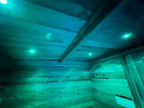 Cedar sauna interior glowing under teal mood lighting