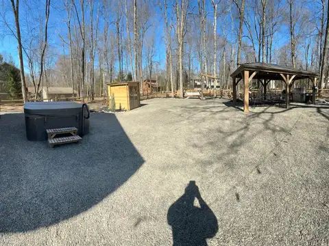 Panoramic backyard view with hot tub and steps, cedar sauna cabin, and gazebo dining pavilion